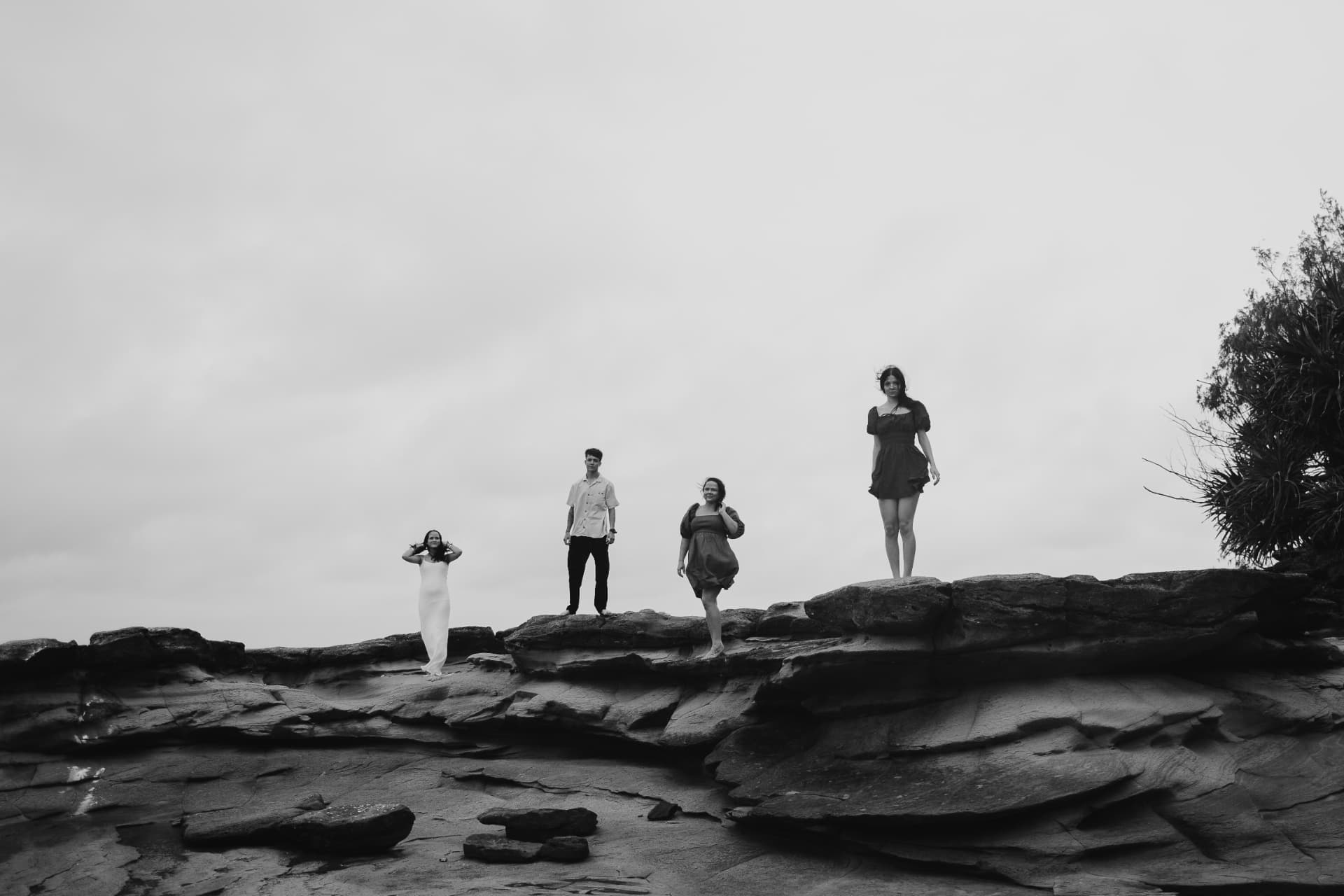 Bianca and her three children standing on coastal rocks under a grey sky